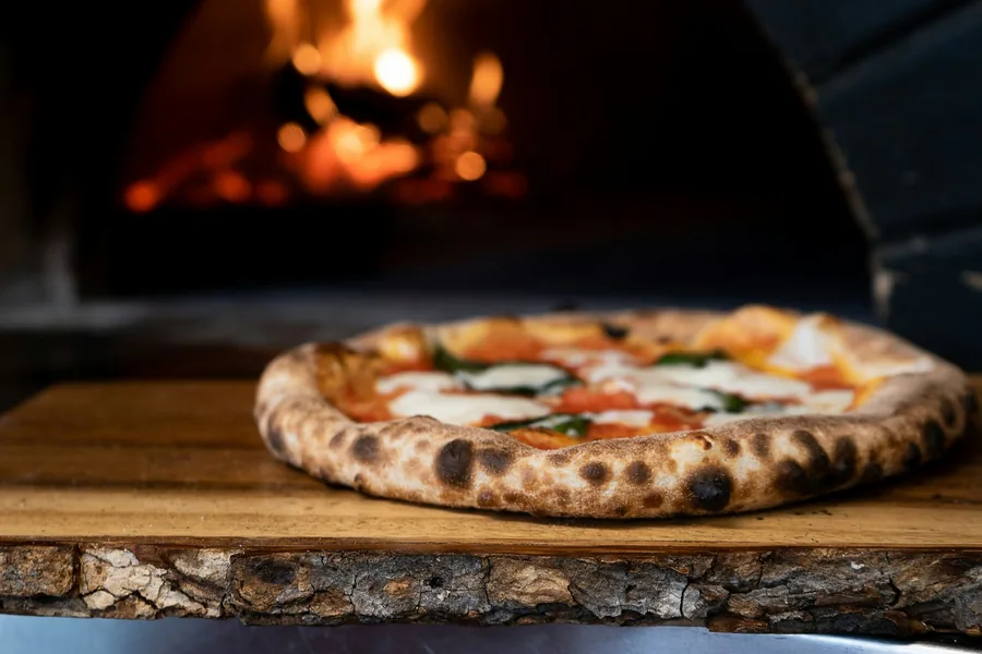 Pizza napolitaine devant le four à bois de Pizza Nova